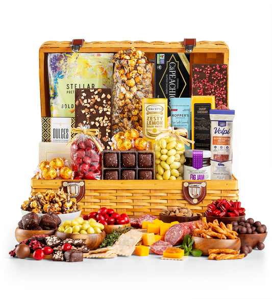 Gourmet food basket with various snacks and cheeses on a white background