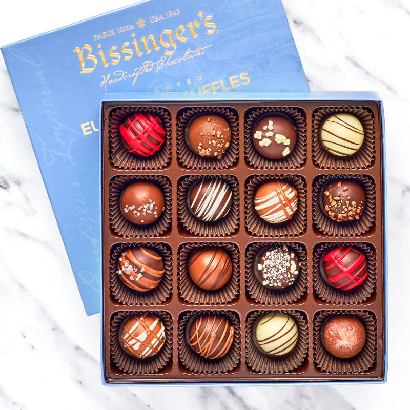 Box of assorted chocolates with a blue Bissinger's box on a marble surface
