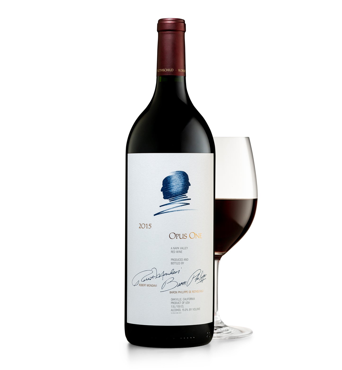 A magnum of Opus One wine, with a wine glass next to it. The bottle is upright and has a label with blue and red text, and a signature at the bottom.