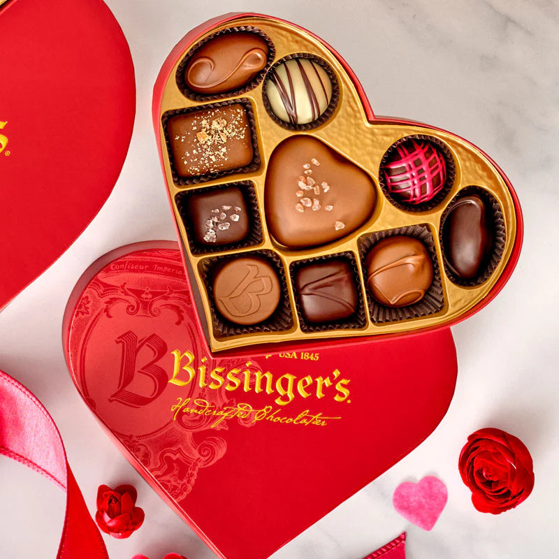 Heart-shaped Bissinger's chocolate box with various chocolates on a white background