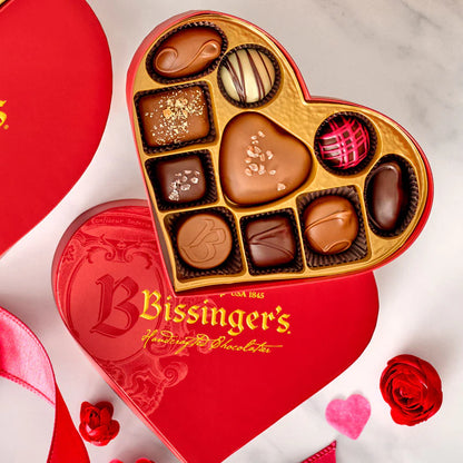 Heart-shaped Bissinger's chocolate box with various chocolates on a white background