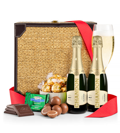 Gift basket with Chandon champagne, chocolates, and candies on a white background