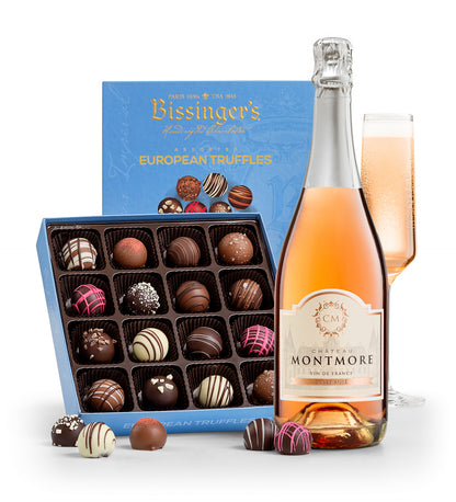 Bottle of Montmore sparkling wine, box of Bissingers European truffles, and a glass of champagne on a white background
