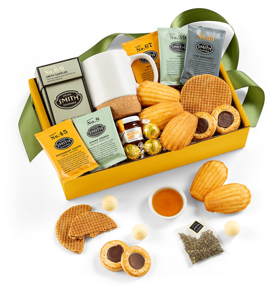 Gift basket with cookies, tea, and a mug on a white background