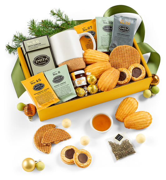 Gift box with cookies, tea, and other treats on a white background