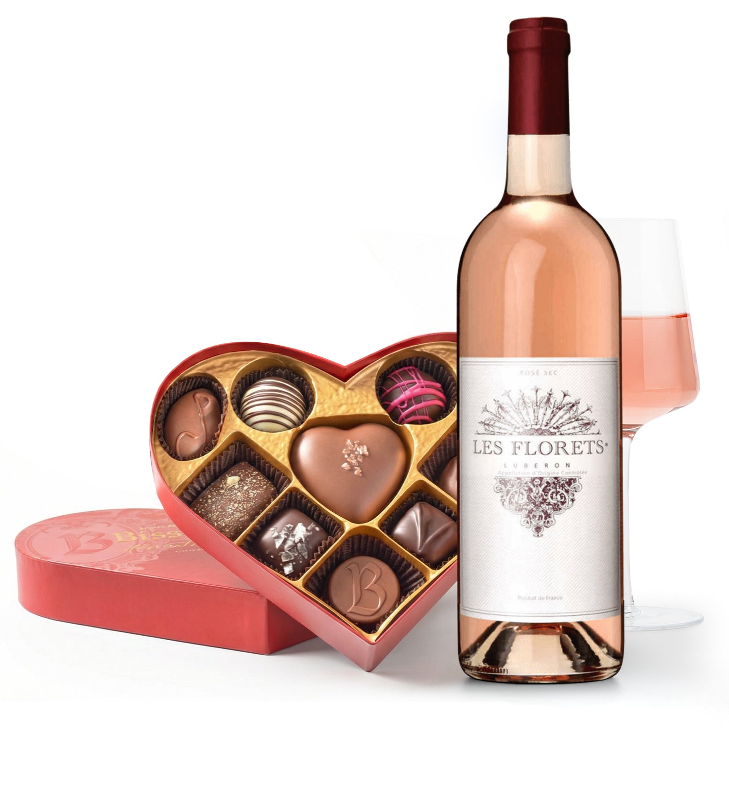 Bottle of Les Floretts rosé wine with a heart-shaped chocolate box on a white background