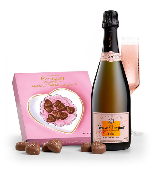Bottle of Veuve Clicquot Rosé champagne with a box of chocolates on a white background