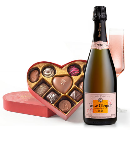 Bottle of Veuve Clicquot Rosé champagne with a heart-shaped chocolate box on a white background
