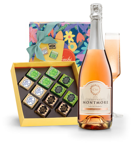 Bottle of Chateau Montmore rose wine with a box of chocolates and a glass on a white background
