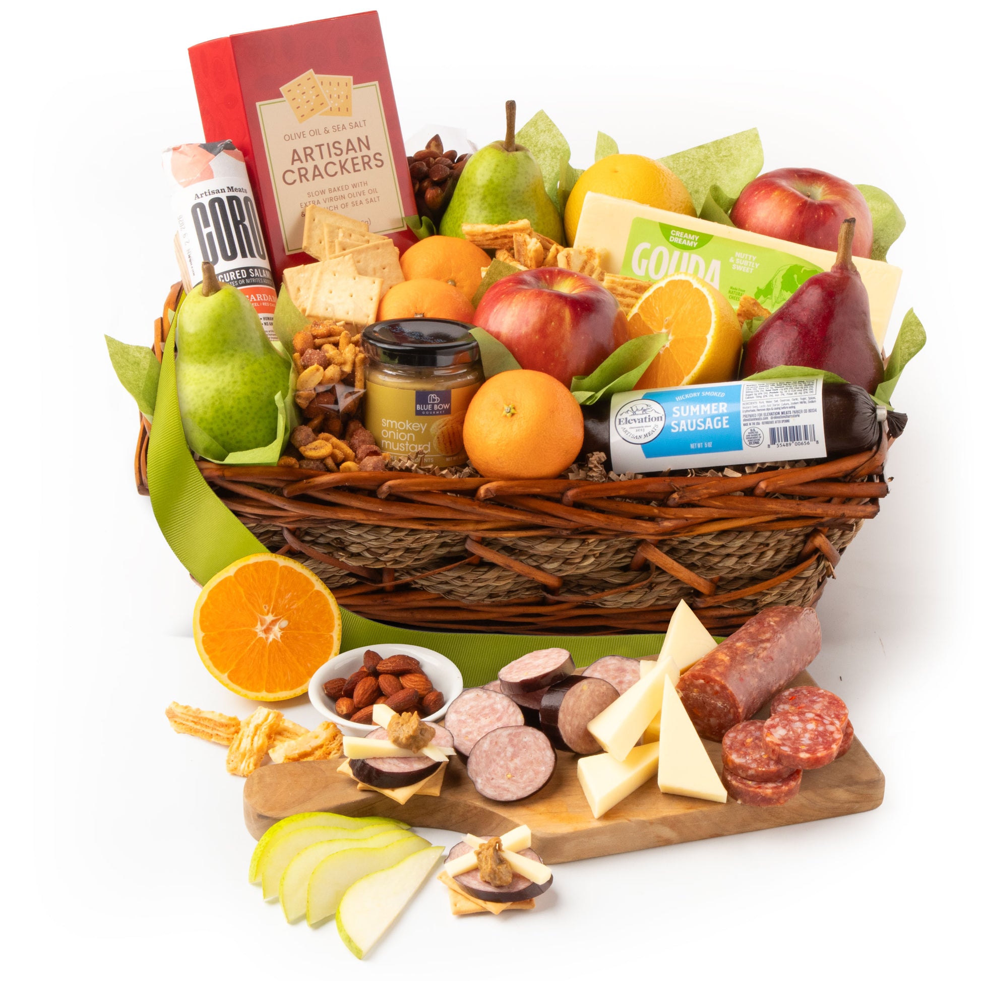 Gourmet gift basket with fruits, cheeses, and meats on a white background
