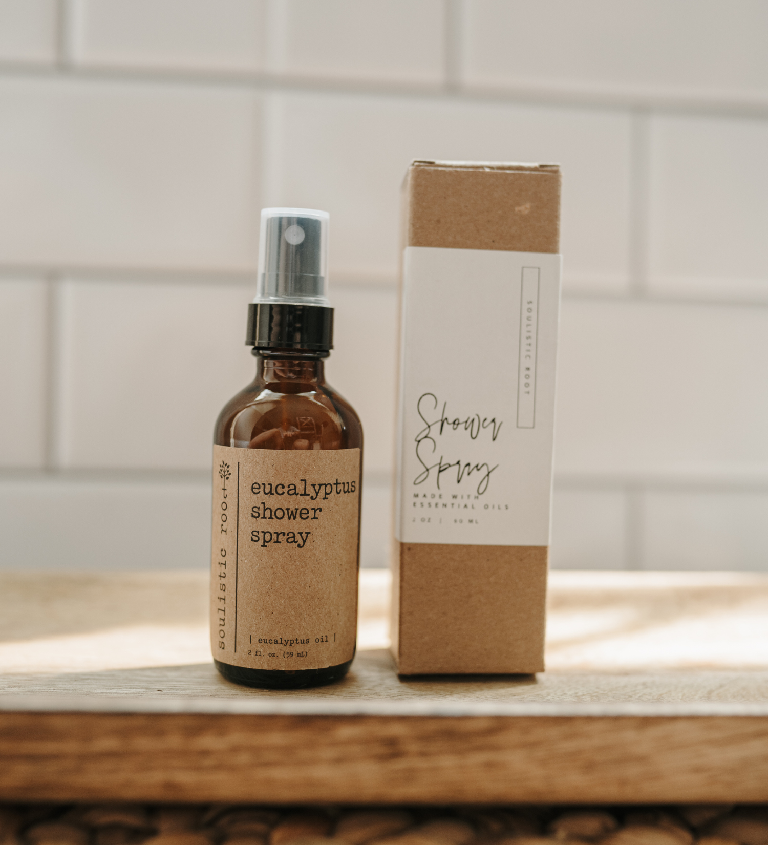 Eucalyptus shower spray bottle and box on a wooden surface with a tiled wall background
