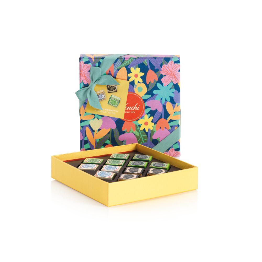 Colorful floral Venchi Cremino Chocolate Gift Set with a yellow interior containing small square items on a white background